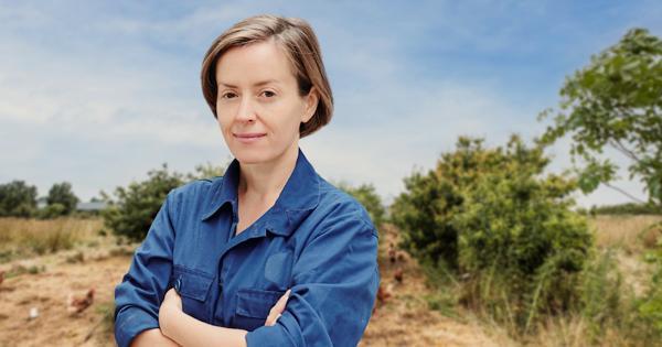 A farmer with crossed arms in a blue shirt