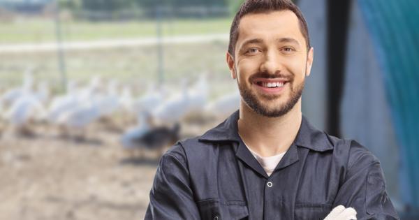 A happy farm worker with geese in the background