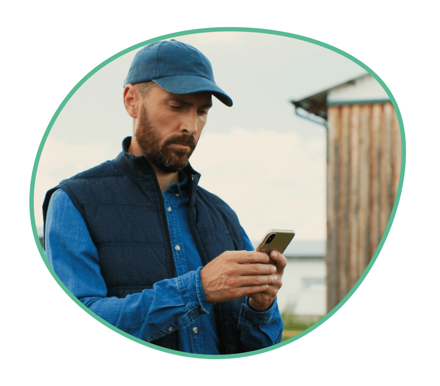 A farmer using The Livetec Farm Health Guardian (FHG) on his mobile phone